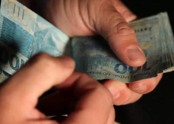 Um estudante contando o dinheiro que ganhou no Caixa Tem