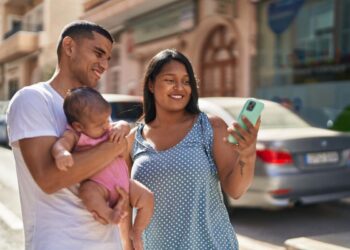 Uma família, pai, filha no colo e mãe, se animam com o feriado prolongado de Outubro