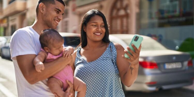 Uma família, pai, filha no colo e mãe, se animam com o feriado prolongado de Outubro