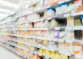 Prateleira embaçada onde ficam produtos como refrigerante