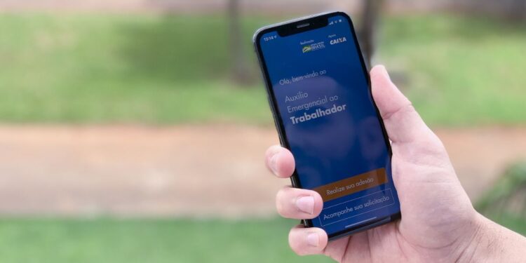 Uma pessoa vendo a tela do Auxílio Emergencial em seu aplicativo