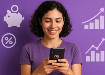 Uma cliente do Nubank com o celular na mão sorri