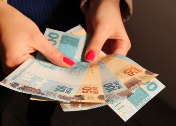 Uma pessoa segurando o valor referente à nova aposentadoria de 2026