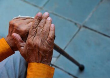 Um senhor segura a bengala após se aposentar