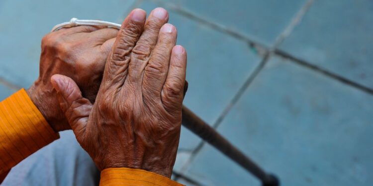 Um senhor segura a bengala após se aposentar