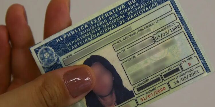 Uma mulher segura seu documento após emissão da nova CNH