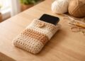 Um celular desligado dentro de uma capinha de crochê