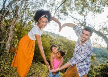 Ilustração de uma "Família tradicional brasileira" entre as possíveis: pai ao lado da mãe fazem coração e ao fundo há duas filhas
