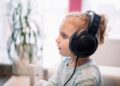 Uma menina com fones de ouvido, ela estuda para a volta às aulas 2026