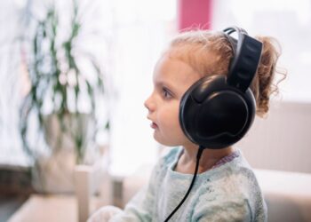 Uma menina com fones de ouvido, ela estuda para a volta às aulas 2026