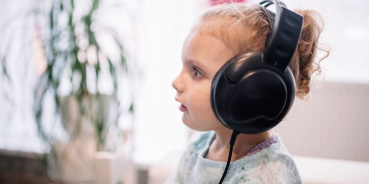 Uma menina com fones de ouvido, ela estuda para a volta às aulas 2026