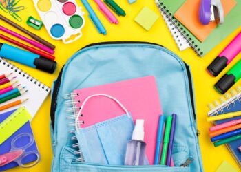 Material escolar ao lado de uma mochila