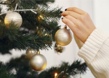 Uma pessoa enfeitando a árvore de natal