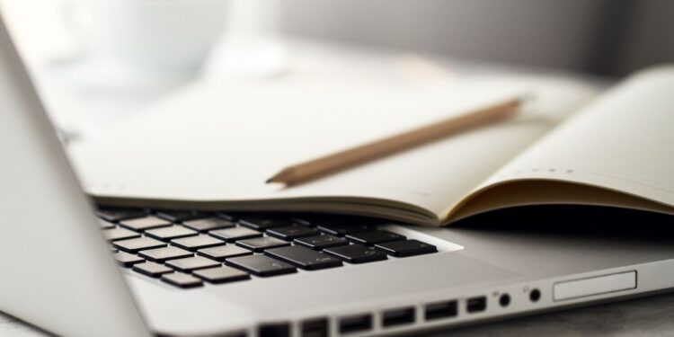 Um notebook com caderno e papel em cima