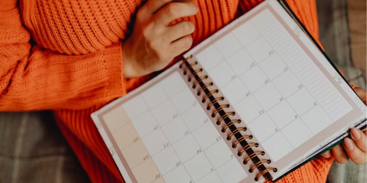 Uma pessoa com calendário calculando quando cai 5º dia útil