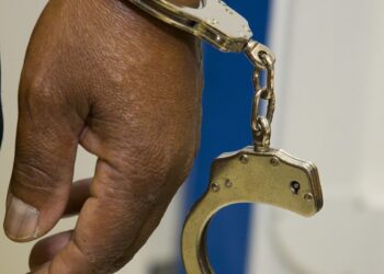 Uma mão algemada após suspeita de fraude com auxílio emergencial