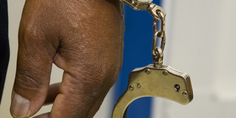 Uma mão algemada após suspeita de fraude com auxílio emergencial