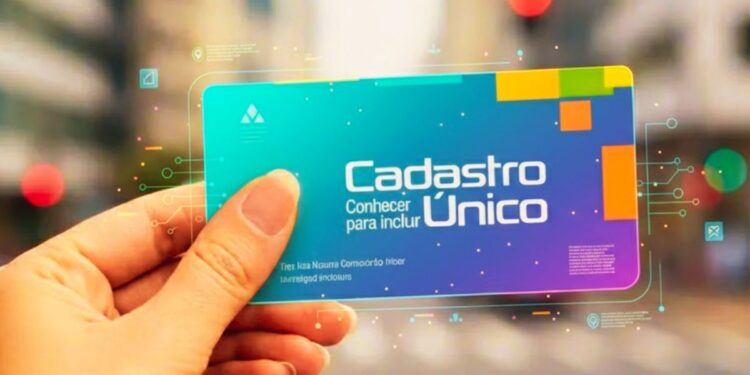 Uma mão segura o cartão do Cadastro Único azul