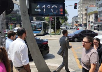 Pessoas andam na rua durante um calor intenso