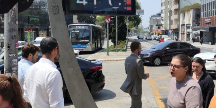 Pessoas andam na rua durante um calor intenso