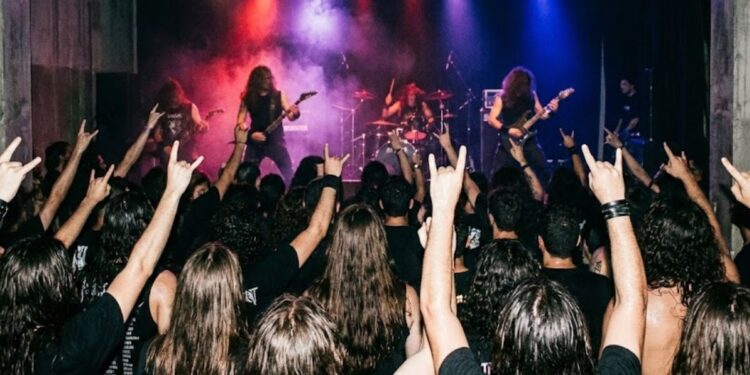 Pessoas em um show de uma banda no Dia Nacional do Heavy Metal