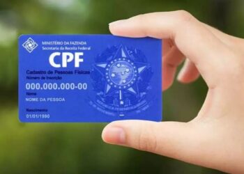 Um cartão de CPF na mão da pessoa que vai consultar o NIS