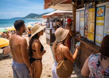 Pessoas na praia comprando em uma barraca