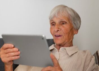 Uma idosa fazendo a prova de vida pelo tablet