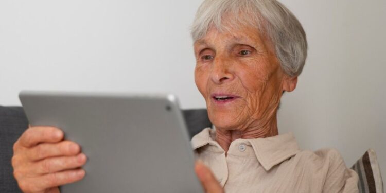 Uma idosa fazendo a prova de vida pelo tablet