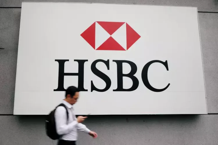 HSBC - Uma pessoa passa em frente ao logo que está na parede