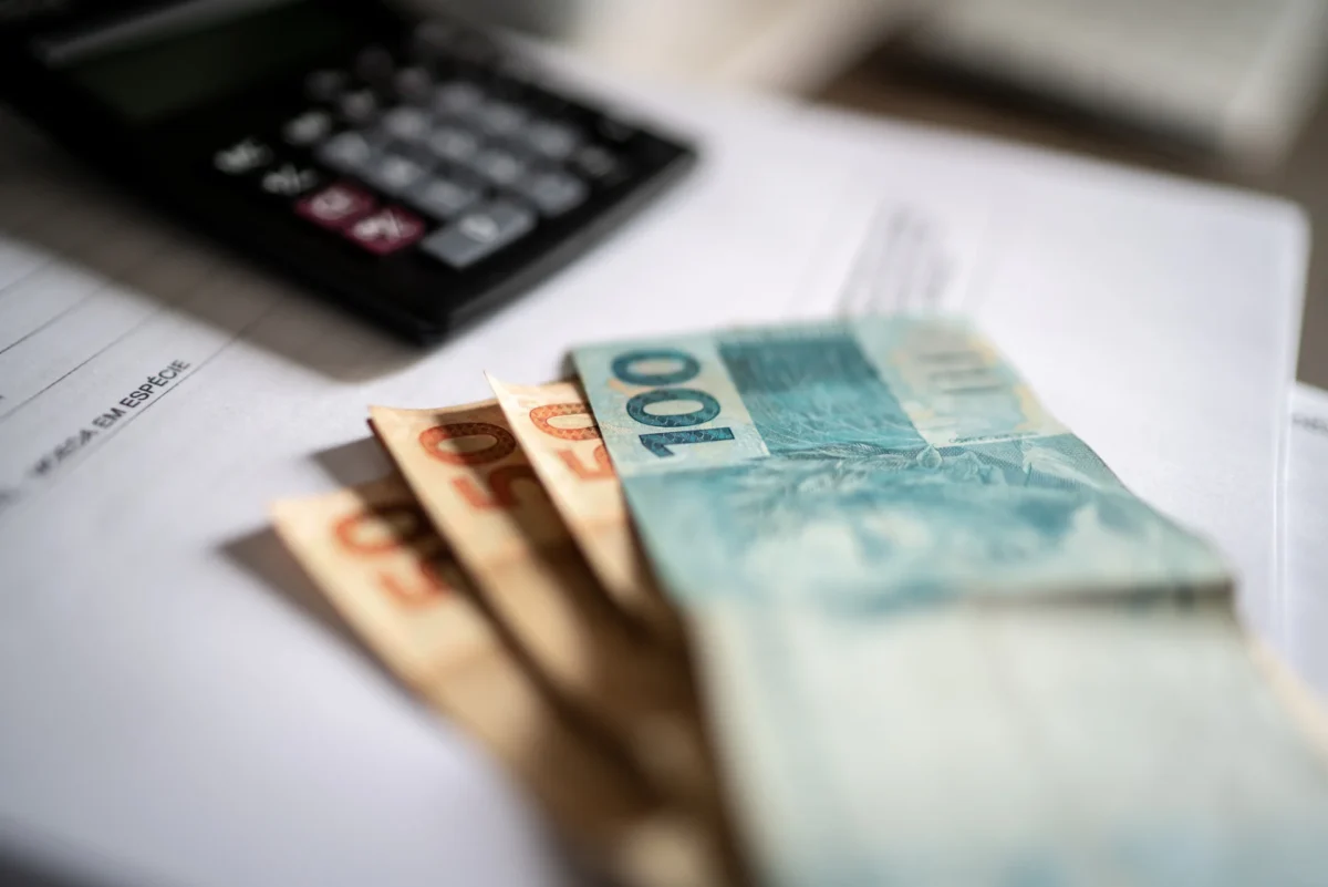 Imagem de dinheiro e calculadora representando o planejamento tributário
