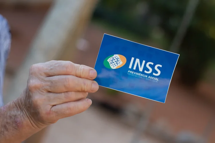 Uma pessoa segura o cartão do INSS após fazer a prova de vida