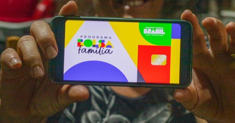 Aplicativo bolsa Família na mão de uma beneficiária