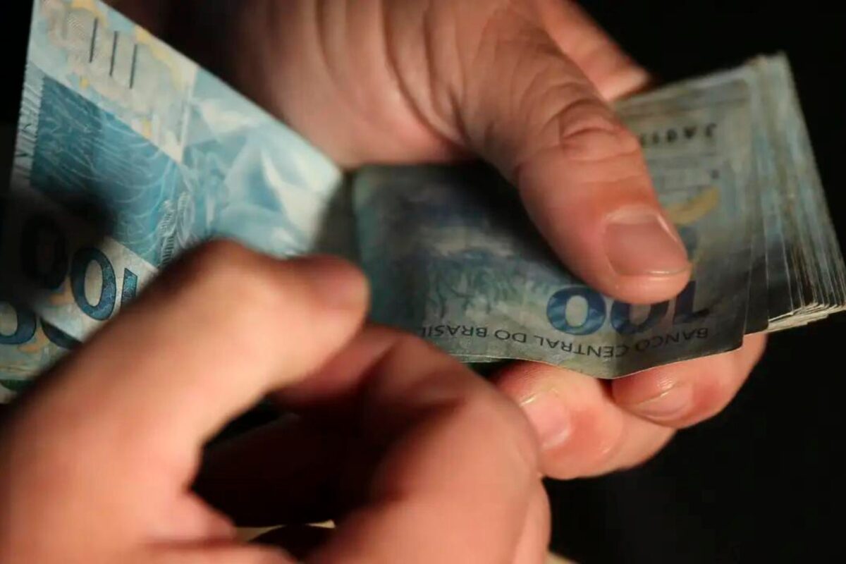 Um estudante contando o dinheiro que ganhou no Caixa Tem