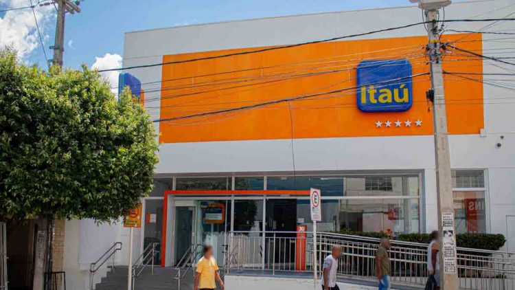 Fachada do Itaú com algumas pessoas passando em frente
