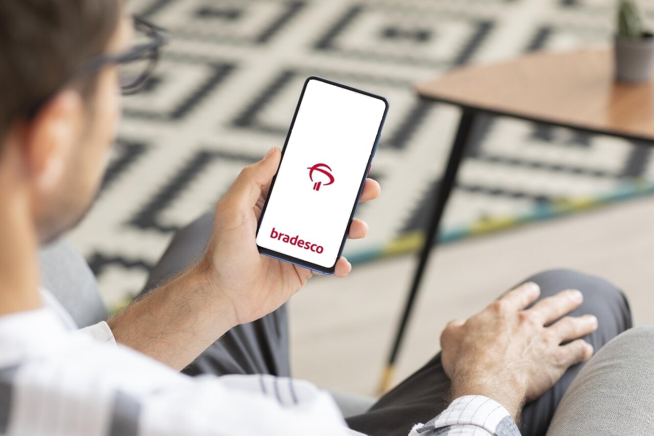 Close de celular com app Bradesco aberto na mão de pessoa 