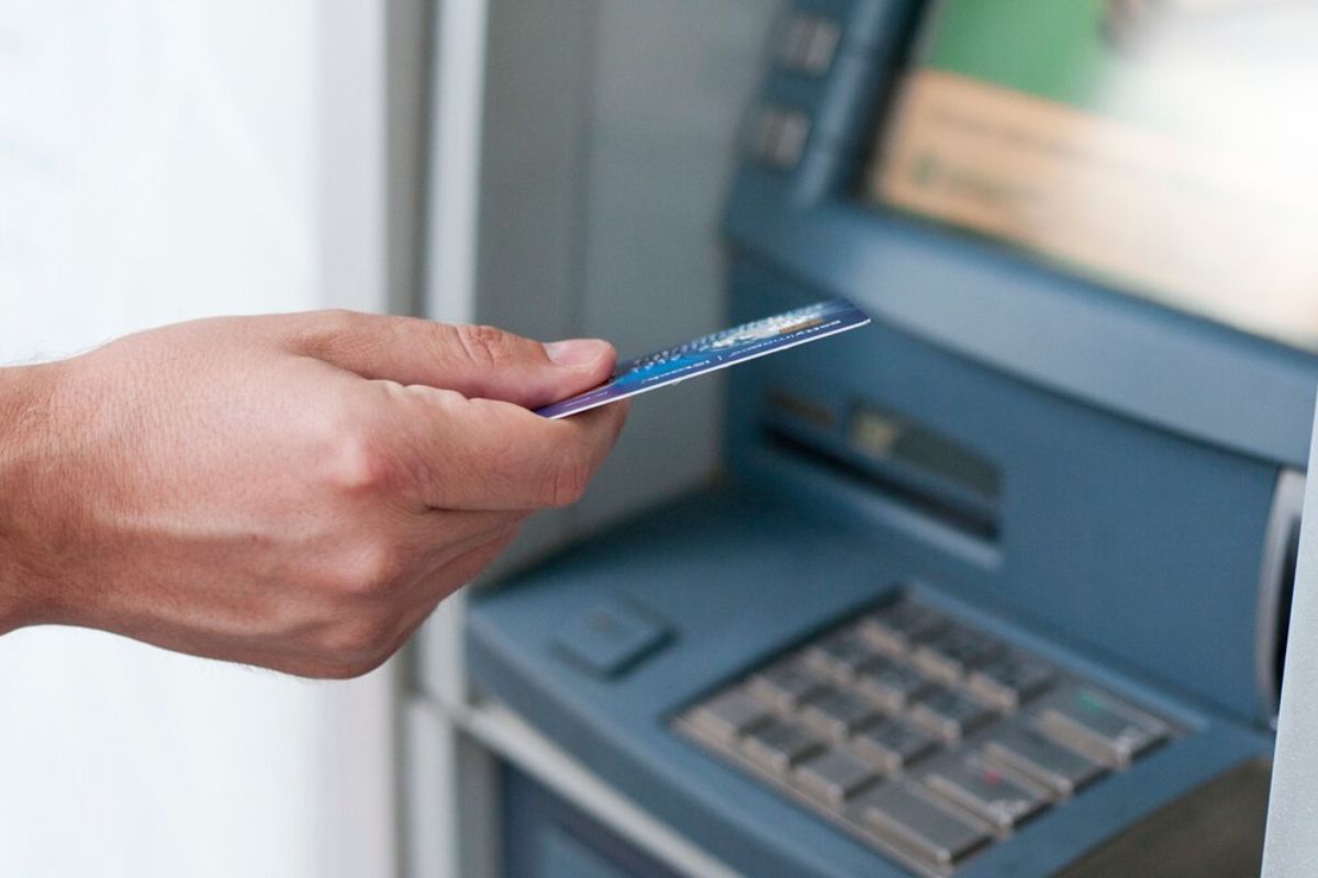 Uma pessoa em frente ao caixa para sacar dinheiro sabendo que os Bancos fecharão na sexta-feira