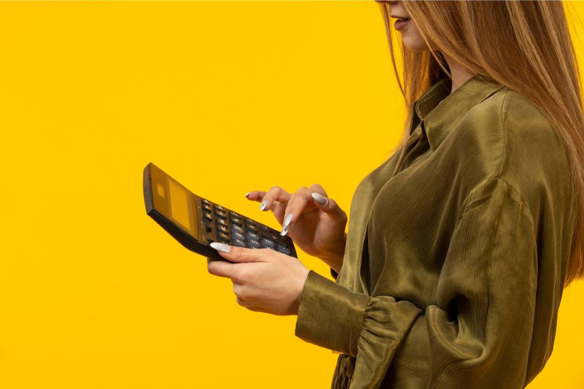 Uma mulher com a calculadora vendo como renegociar dívidas