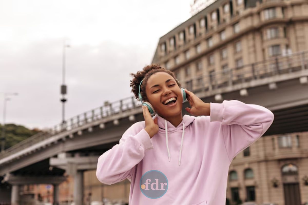 Uma mulher dançando na rua mostrando que a música pode influenciar suas emoções