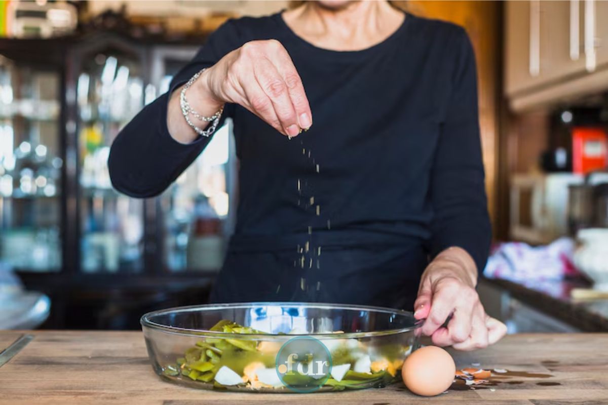 Uma mulher tempera a comida que tem o mineral essencial