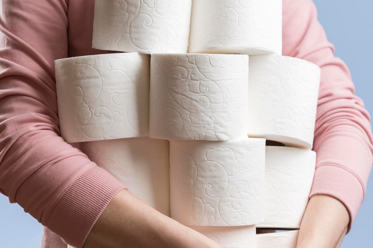 Uma mulher segurando Papel higiênico mais caro