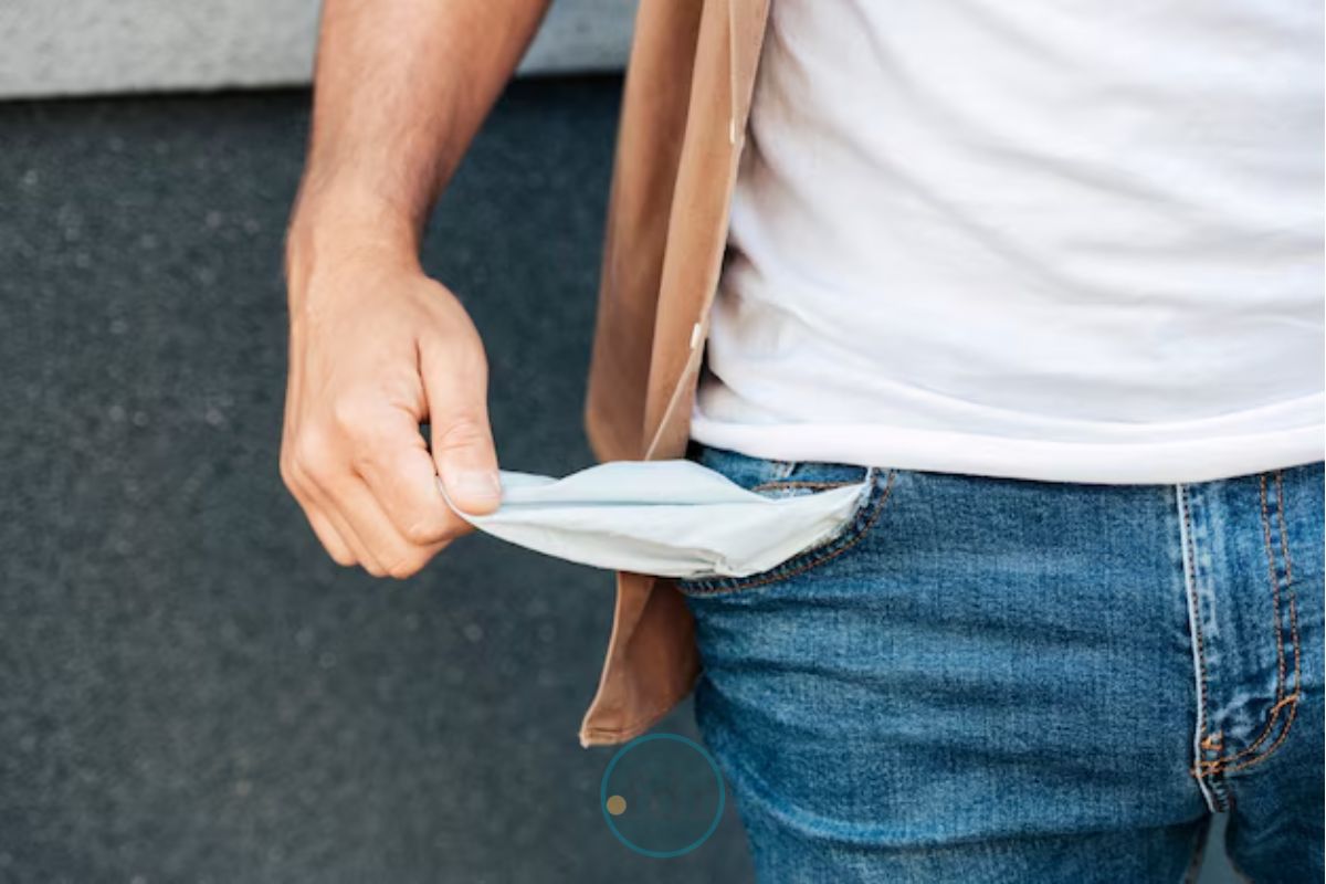 Um homem mostrando que não há nada em seu bolso, revelando por que em abril brasileiros ficaram sem dinheiro
