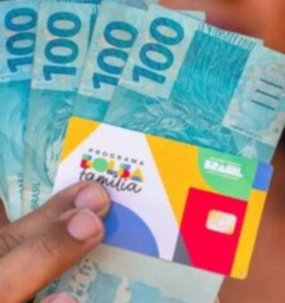 Uma moça com o dinheiro de benefício depois de ver que o Bolsa Família VAI começar no dia 19/05