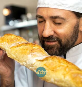 Um padeiro apreciando o cheiro do pão fresquinho