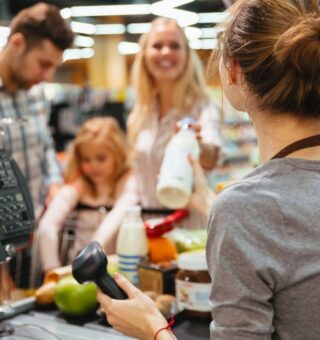 Uma família passando pelo caixa depois de aprender Como fazer compras inteligentes no supermercado
