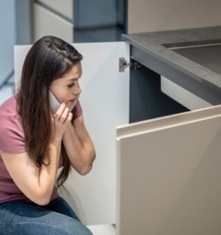 Uma mulher assustada em sua cozinha querendo economizar gás de cozinha