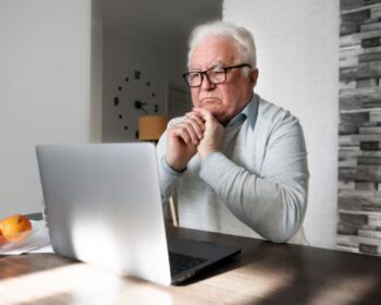 Um senhor com notebook vê como pedir a aposentadoria sendo MEI