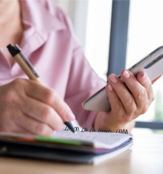 Uma mulher com caneta e caderno aprendendo a