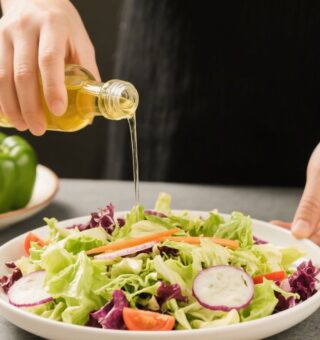 Uma pessoa temperando a salada após ver que vinagre ajuda a absorver melhor o ferro