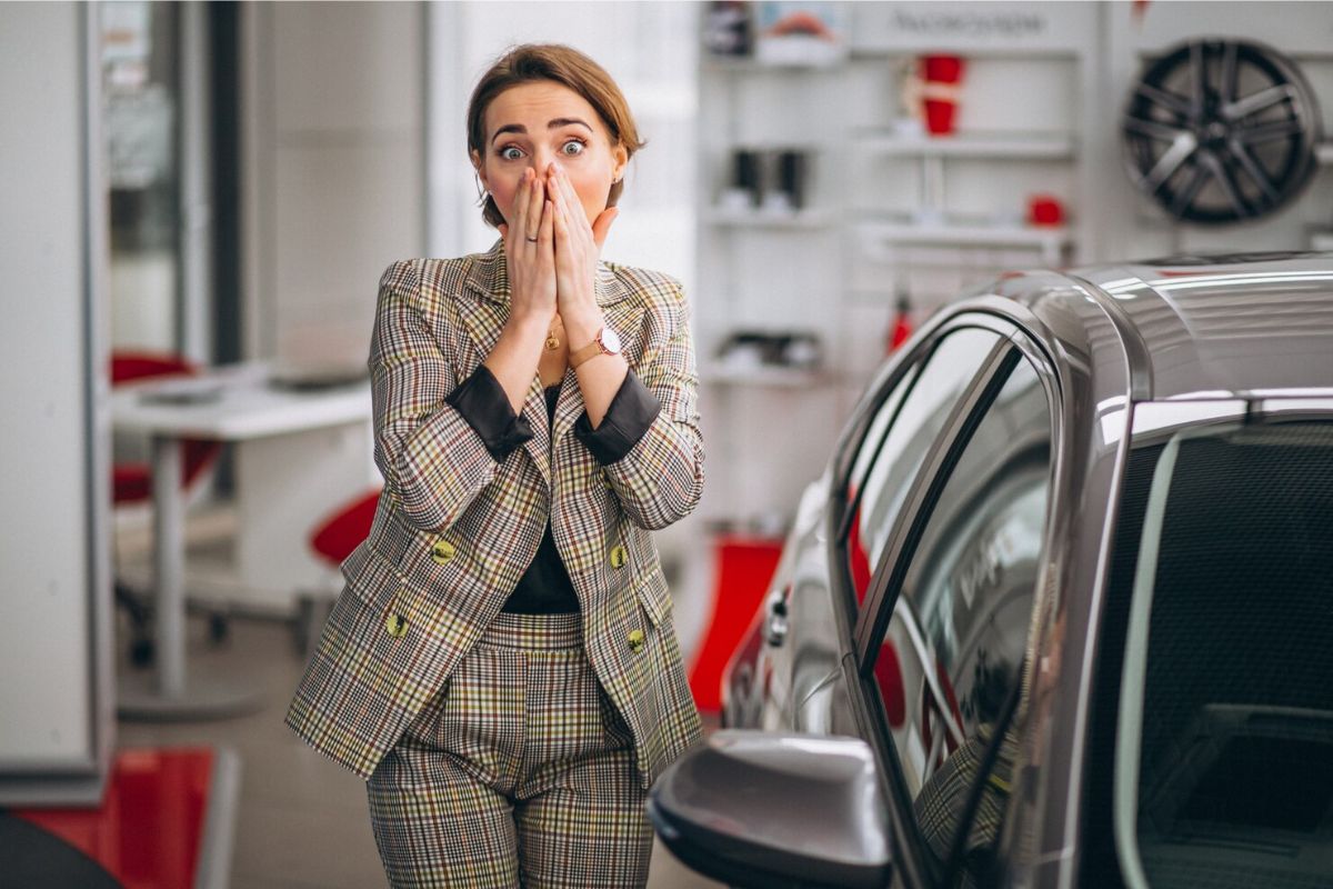 Uma mulher assustada ao ver os novos preços dos carros em 2025